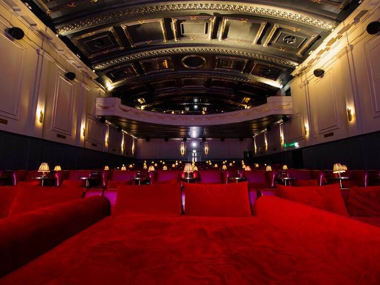 The ornate interior and neon lights of a historic global cinema