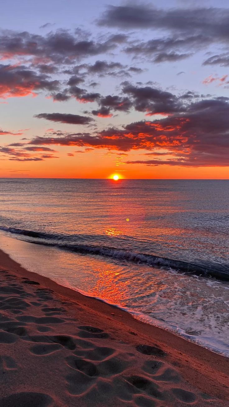 Vibrant purple and orange sunset over water for mobile phone