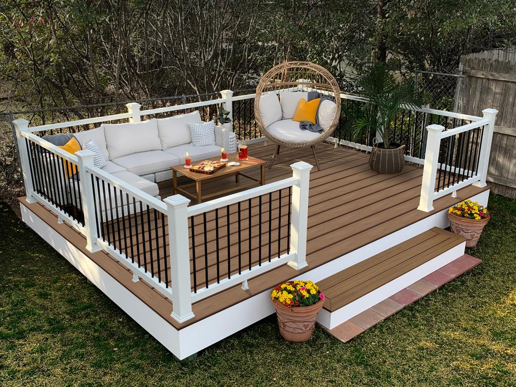 A small, well-organized deck with built-in seating and white railings