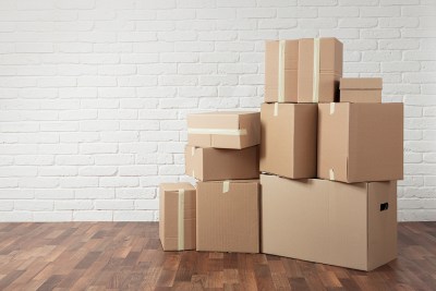 Stacked moving boxes of various sizes in a room