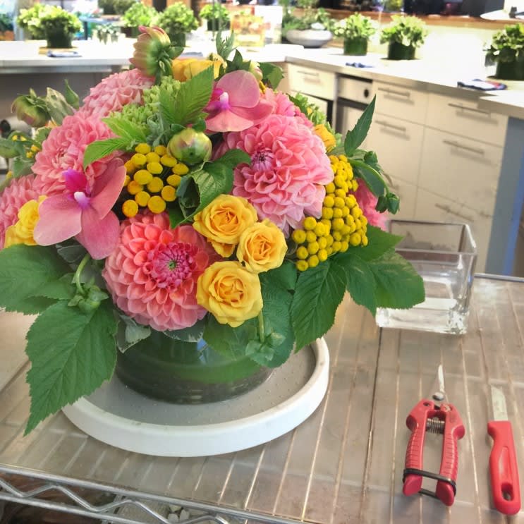 Student working on a complex floral arrangement in a professional studio