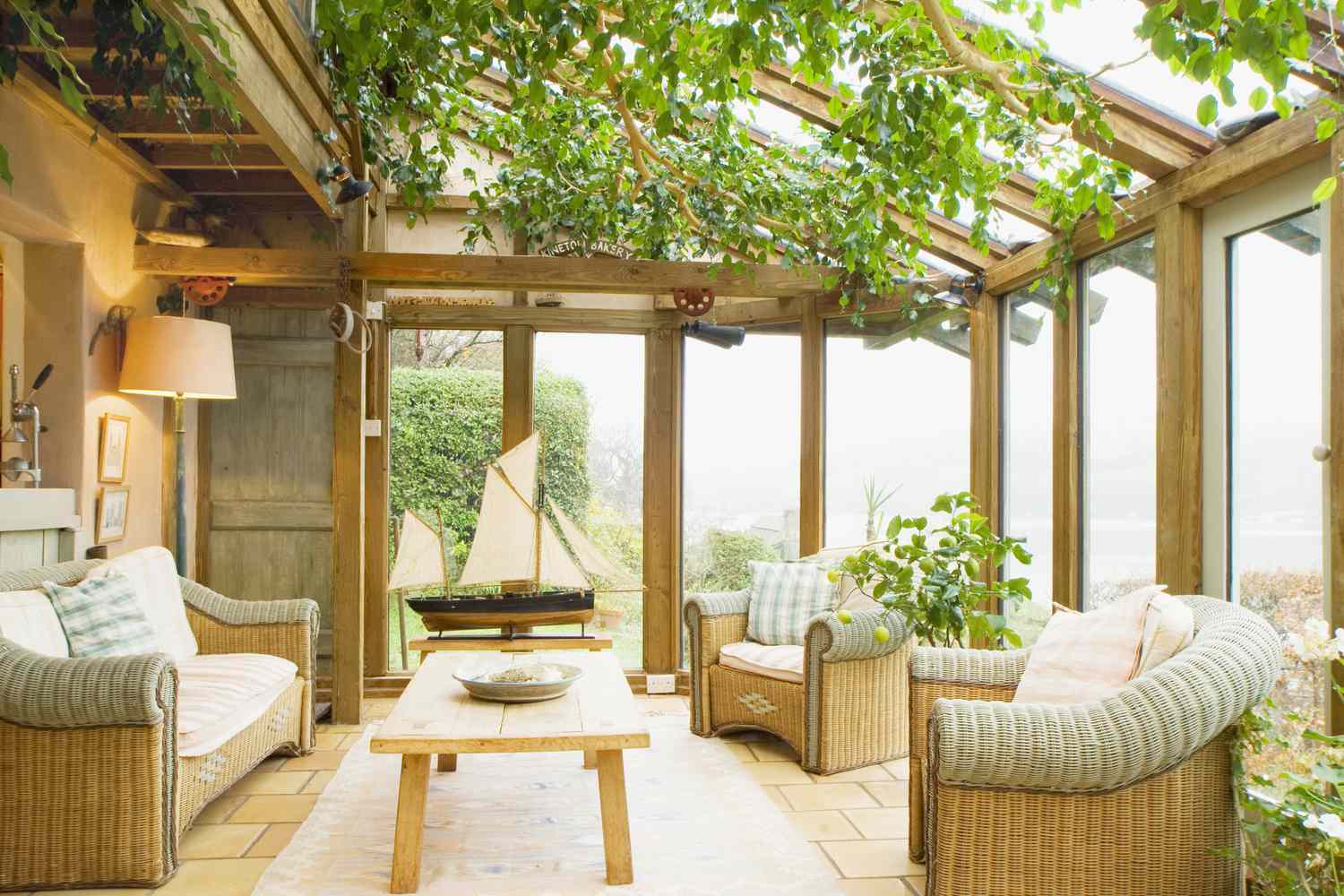 A lush sunroom design featuring ivy and natural wood frames