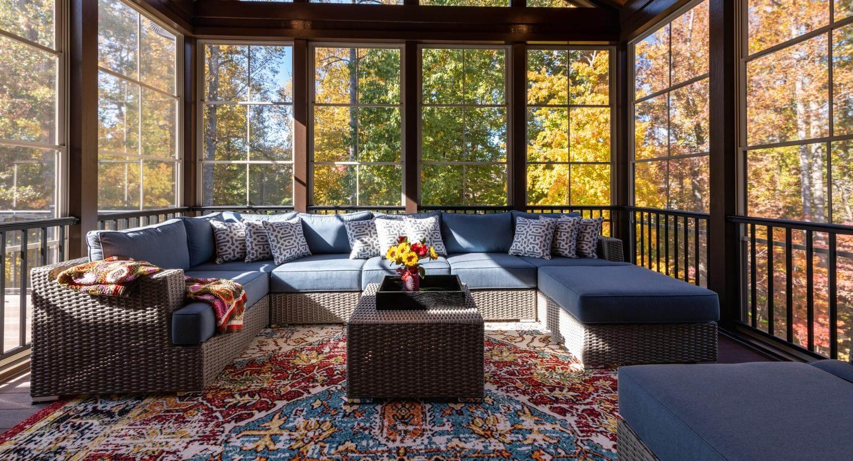 A modern sunroom with large windows and seasonal decor